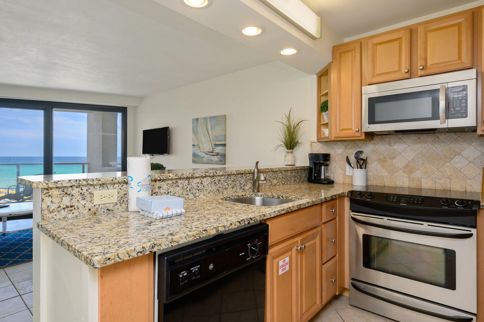 4277 Beachside 2, Unit 4277 Miramar Beach, FL 32550 - Photo 9 of 71 a kitchen with stainless steel appliances granite countertop a sink stove and microwave