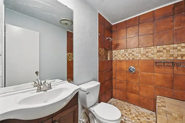 a bathroom with a sink a toilet and shower