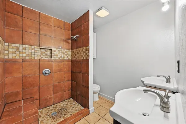 a bathroom with a sink a toilet and shower