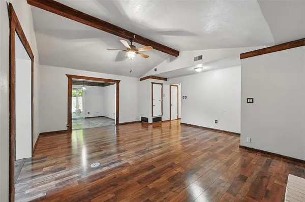 a view of empty room with wooden floor