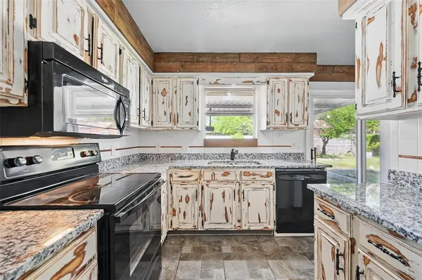 a kitchen with stainless steel appliances granite countertop a stove sink and cabinets