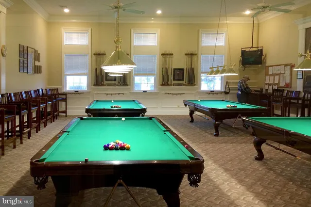 a room with pool table table and sofas