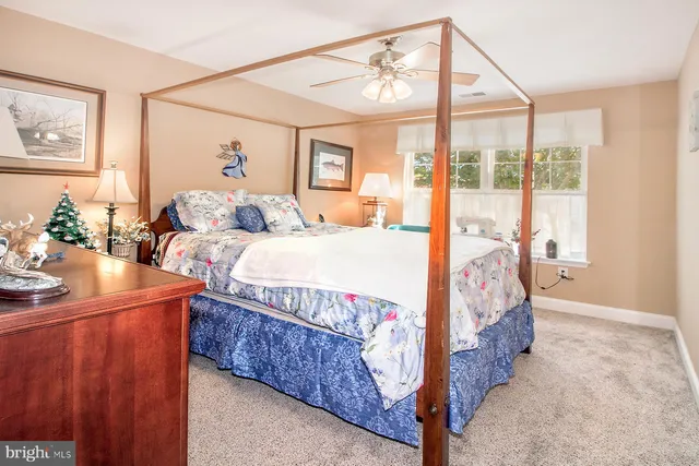 a bedroom with a bed and large windows