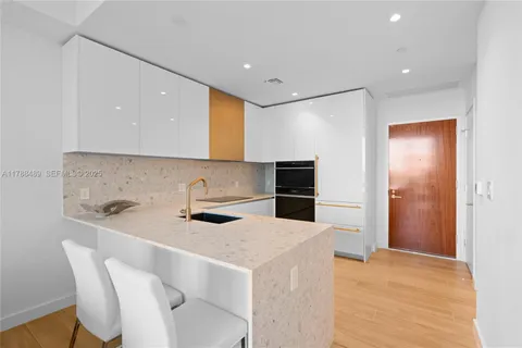 a kitchen with stainless steel appliances a stove a sink a refrigerator and cabinets