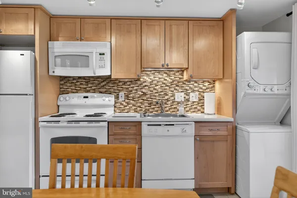 a kitchen with granite countertop a sink stove and refrigerator