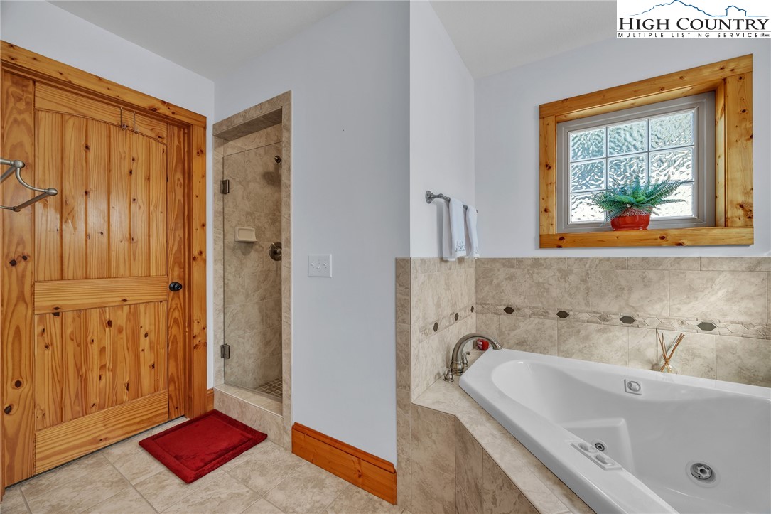 1118 Lucy Bell Road Crumpler, NC 28617 - Photo 16 of 39 a bathroom with a tub sink and mirror