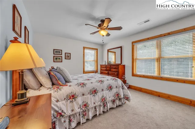 a bedroom with a bed and a lamp on dresser