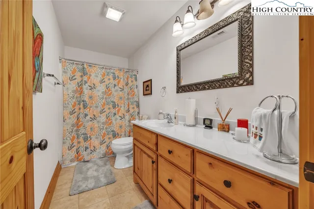 a bathroom with a granite countertop sink mirror vanity and toilet