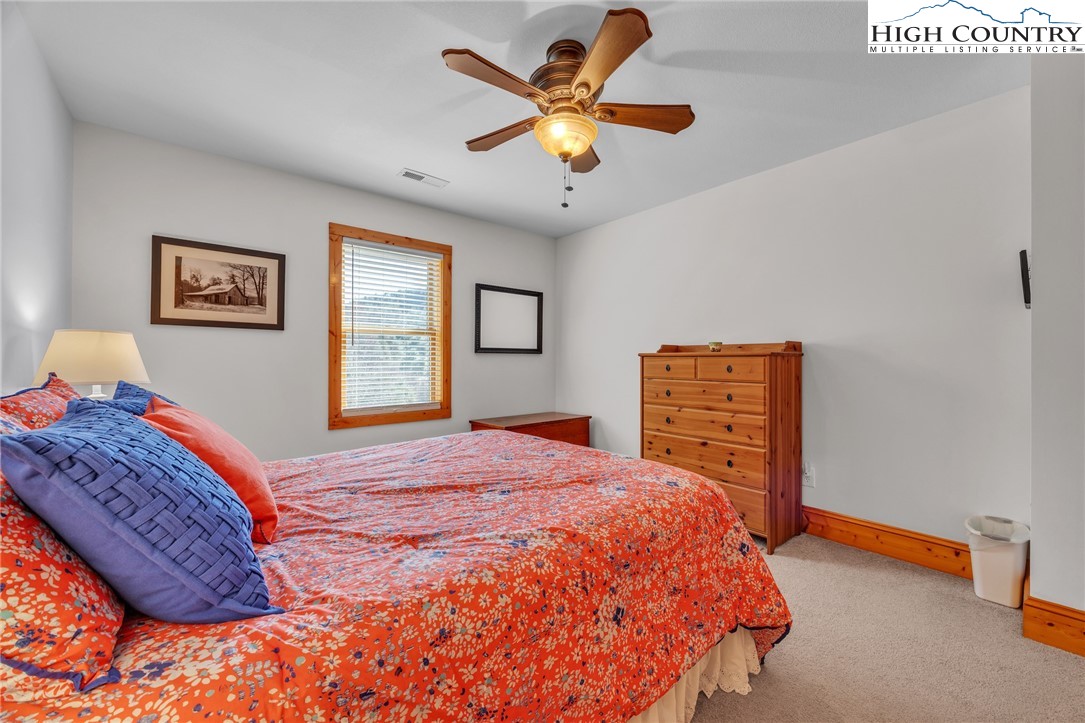 1118 Lucy Bell Road Crumpler, NC 28617 - Photo 29 of 39 a bedroom with a bed and a chandelier