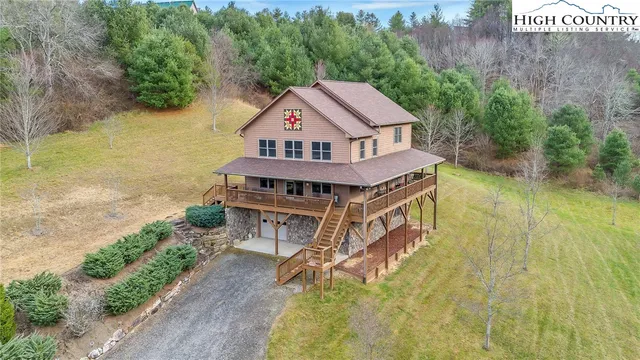 an aerial view of a house with a big yard and large trees