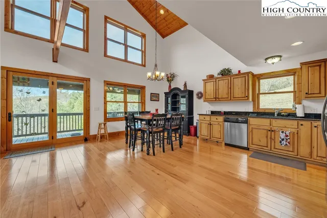 a open kitchen with stainless steel appliances granite countertop a stove top oven a sink and dining table with wooden floor