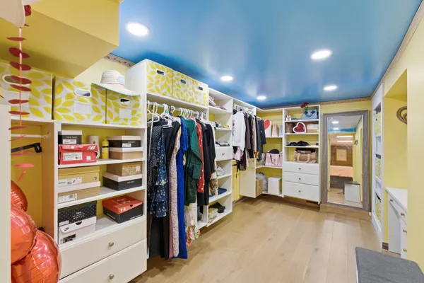 a view of walk in closet with wooden floor