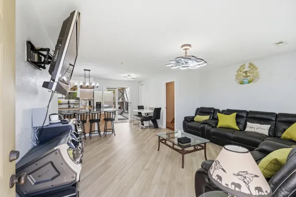 a living room with furniture a flat screen tv and a large window
