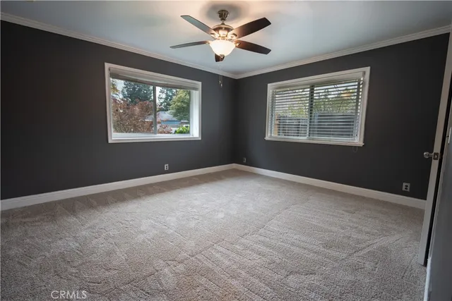 an empty room with closet and a ceiling fan