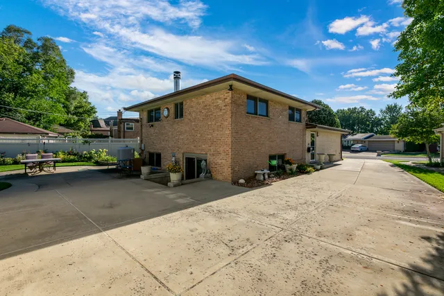 a patio with a table and chairs and potted plants