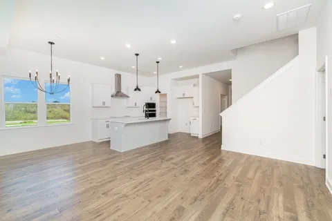 a large kitchen with kitchen island a stove a sink dishwasher and a oven with white cabinets