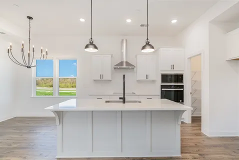a kitchen with kitchen island a counter space a sink appliances and a window