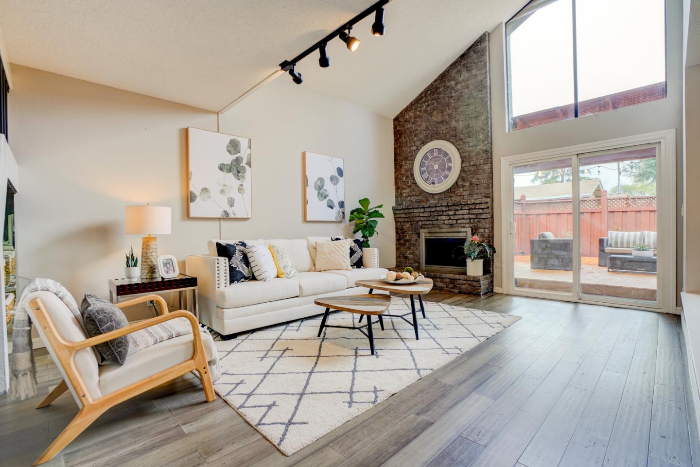 a living room with furniture a fireplace a clock and a large window