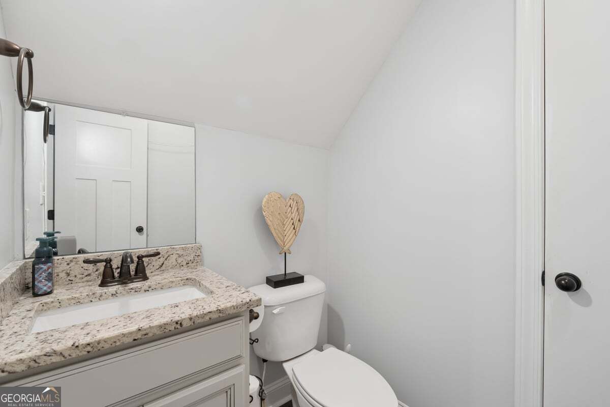 683 Teagle Road Forsyth, GA 31029 - Photo 29 of 50 a bathroom with a granite countertop sink a toilet and a mirror