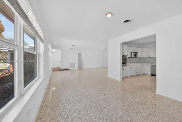 a kitchen with granite countertop a sink stainless steel appliances and white cabinets
