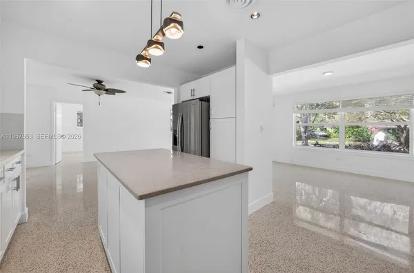 a kitchen with stainless steel appliances granite countertop a sink and a refrigerator