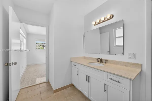an empty room with a window and ceiling fan