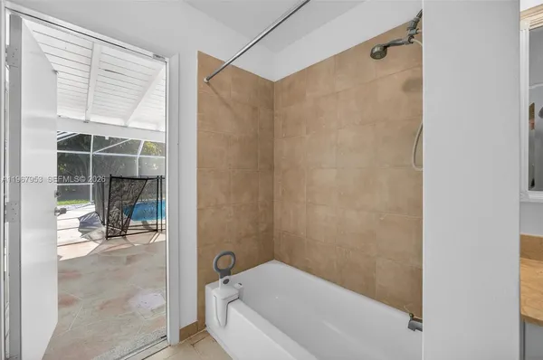 a bathroom with a granite countertop sink mirror and a bathtub