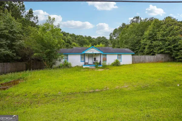 a front view of a house with yard and green space