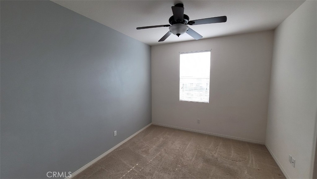 22056 Windham Way Saugus, CA 91350 - Photo 17 of 35 an empty room with a chandelier fan and windows
