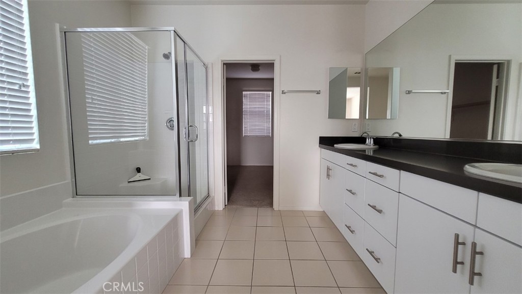 22056 Windham Way Saugus, CA 91350 - Photo 19 of 35 a spacious bathroom with a granite countertop sink a mirror and a bathtub