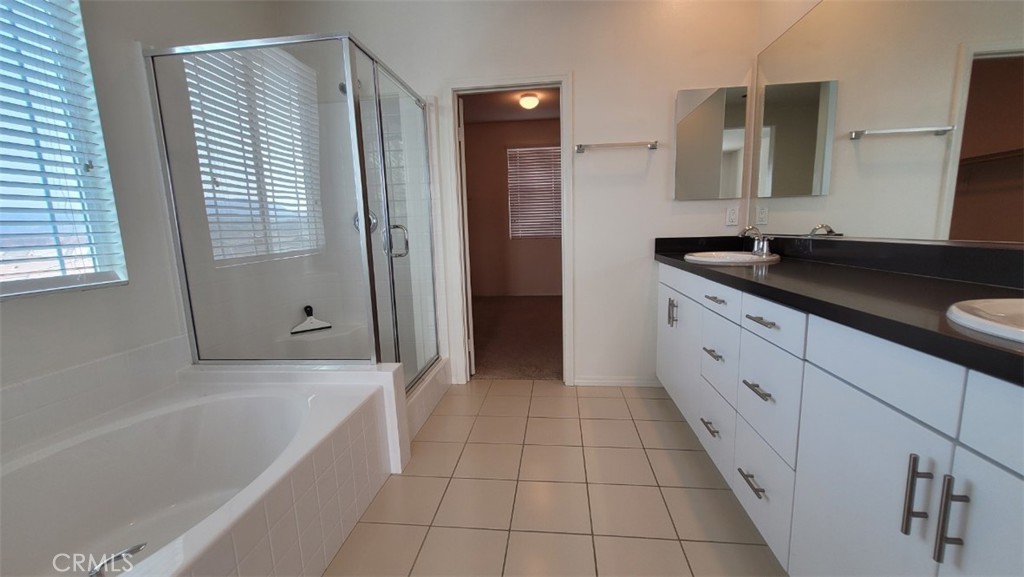 22056 Windham Way Saugus, CA 91350 - Photo 25 of 35 a bathroom with a granite countertop sink a mirror and a bathtub