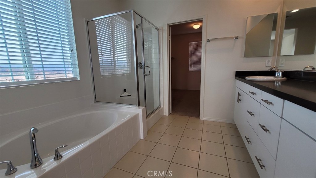 22056 Windham Way Saugus, CA 91350 - Photo 26 of 35 a bathroom with a granite countertop sink a bathtub and a shower