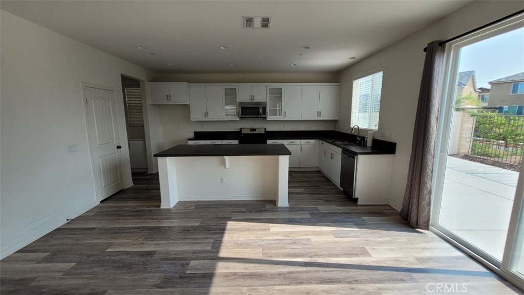 22056 Windham Way Saugus, CA 91350 - Photo 5 of 35 a kitchen with stainless steel appliances granite countertop a refrigerator a sink and white cabinets with wooden floor