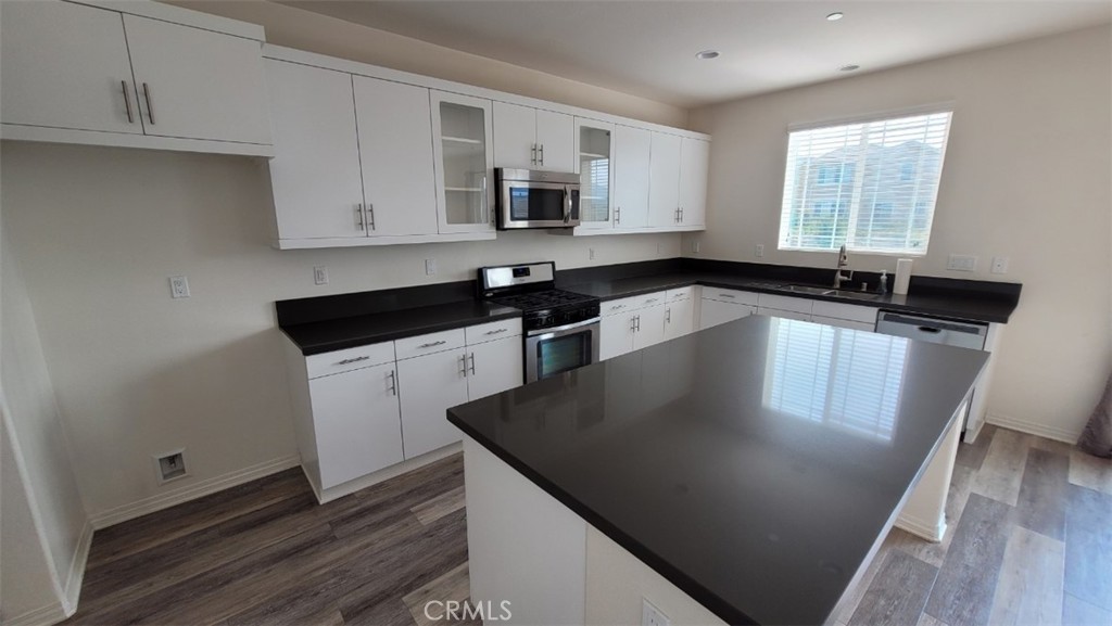 22056 Windham Way Saugus, CA 91350 - Photo 8 of 35 a kitchen with granite countertop stainless steel appliances a sink stove top oven and microwave