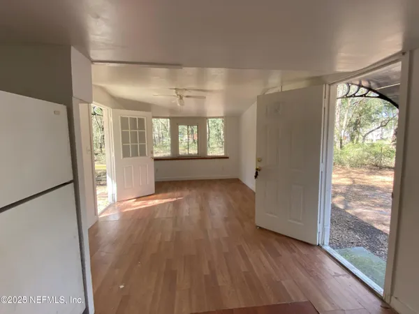 a view of empty room with wooden floor and outdoor view