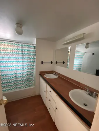 a bathroom with a granite countertop sink and a large mirror