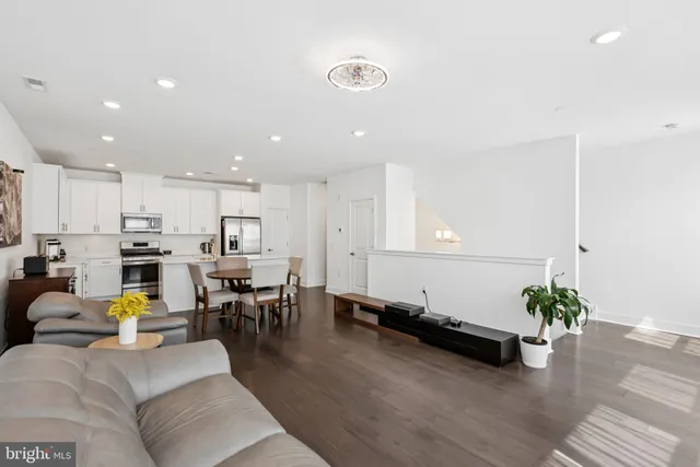 a living room with kitchen island furniture and a chandelier