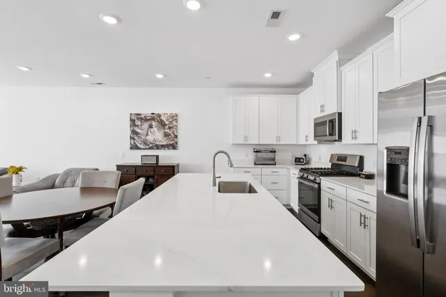 a large white kitchen with stainless steel appliances
