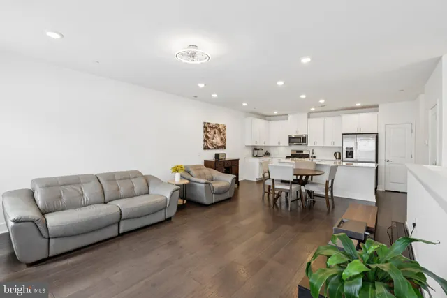 a living room with furniture kitchen view and a dining table