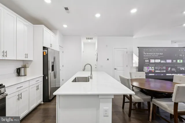 a kitchen with granite countertop a table chairs stove and kitchen island