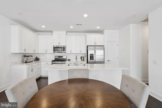 a kitchen with stainless steel appliances granite countertop a refrigerator sink and stove