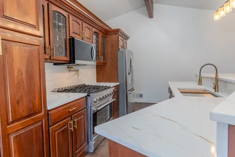 a kitchen with stainless steel appliances granite countertop a stove top oven a sink and dishwasher