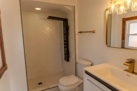 a bathroom with a sink a toilet and shower
