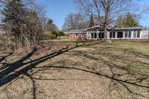 a view of residential houses with yard and trees