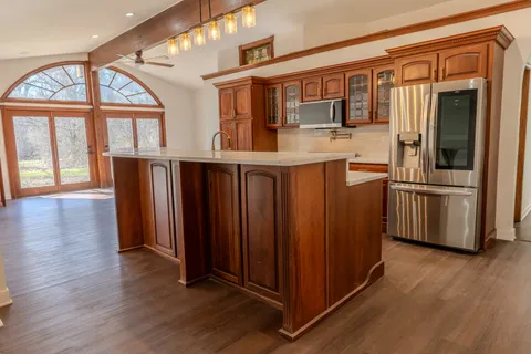 a kitchen with stainless steel appliances granite countertop a refrigerator and wooden cabinets