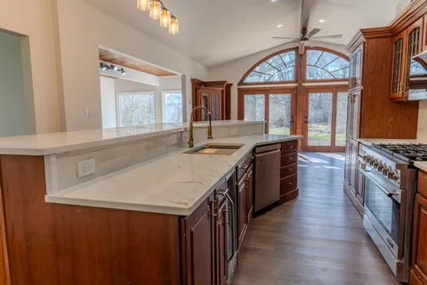 a kitchen with stainless steel appliances granite countertop a sink and a stove