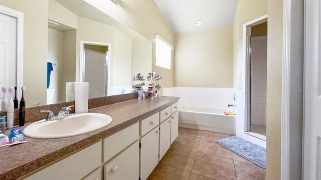 a bathroom with a granite countertop sink and a mirror a bathtub