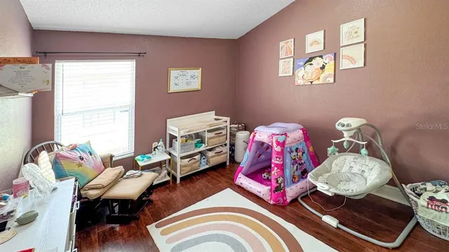 a bedroom with baby bed and a window