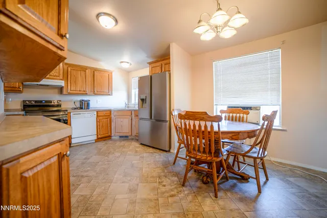 a kitchen with stainless steel appliances granite countertop a refrigerator a stove and a sink with wooden cabinets