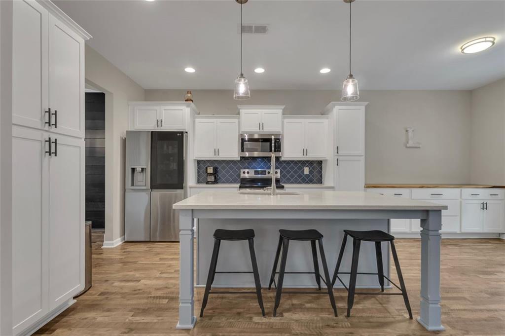 313 Lucy Lane Carrollton, GA 30117 - Photo 11 of 46 a kitchen with stainless steel appliances granite countertop a table chairs refrigerator and microwave